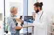 © sofiko14 - Veterinarian presents x-ray results to young female pet owner holding cat at clinic. Interaction highlights professional healthcare, client consultation, animal care, and human-animal bond.