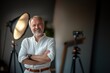 © vernStudio - A man in stylish white shirt with grey hair and beard smiling warmly on a studio background. Image for topics about business, lifestyle and positive aging concepts