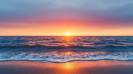 Poster - Sunset over ocean landscapes idea. Vibrant sunset over ocean waves reflecting warm colors on sandy beach.