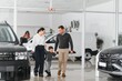 © Serhii - Happy family buying a new car at the car showroom