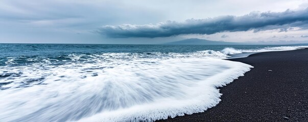 Poster - Beach waves landscapes idea. Waves crashing on a black sand beach under a cloudy sky, evoking tranquility.