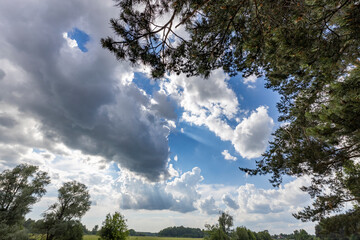 Wall Mural - the sky is cloudy and the sun is shining through the clouds