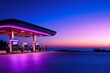 © Gatherina - Futuristic gas station illuminated with neon lights at sunset on the coast