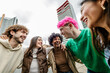 © Xavier Lorenzo - Multiracial young group of friends enjoying time together laughing outside. Millennial generation people having fun embracing each other while hanging out at city street. Diversity and community