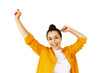 © Kateryna - Joyful young caucasian woman in a yellow shirt celebrates success with raised arms, smiling happily, standing on white isolated background. Concept of success, achievement, and happiness