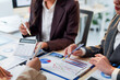 © Crystal - Business team working with financial data analyzing charts and using calculator during a meeting in the office