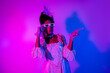 © deagreez - Elegant woman in vintage dress and lace enjoying vibrant neon lights at a colorful masquerade party
