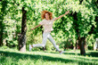 © deagreez - Photo of nice young woman jumping wear t-shirt free time walk fresh air trees park outdoors
