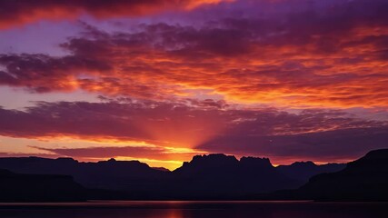 Poster - Vibrant sunrise timelapse over mountain horizon reflecting on calm water, 4K sunrise timelapse close up over horizon mountain clouds