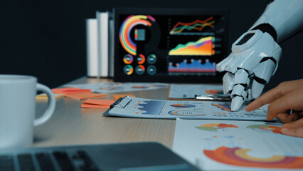 Poster - a robot hand interacts with data analysis documents on a desk, showcasing charts and graphs, symboli