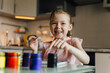 © ADDICTIVE STOCK - Little artist painting joyfully in a brightly lit kitchen