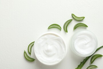 Wall Mural - moisturizing cream with extract of aloe vera and cut leaves on white textured background, flat lay. 