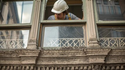 Aufkleber - Professional builder carefully examining an old window frame, assessing the damage and preparing for restoration work on a historical building facade