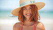 © Inspire Shots Hub - Smiling woman with red hair wearing a straw hat and swimsuit top at the beach, conveying summer joy and carefree attitude