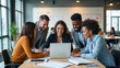 © Eduardo Accorinti - Group of cheerful multiethnic businesspeople smiling while collaborating on project, coworkers gathering around businesswoman working on laptop in spacious office, showcasing teamwork and success