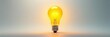 © OneWayPhoto - Bright glowing yellow light bulb illuminates a white background with vibrant energy and futuristic electronics , LED, glow