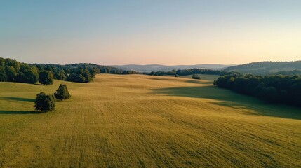 Poster - National park scenic landscapes idea. A scenic view of rolling green hills under a clear blue sky at sunset.