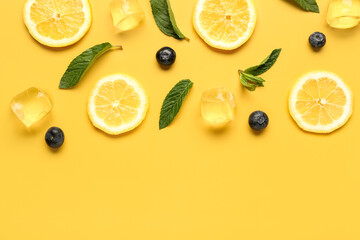 Wall Mural - Lemon slices with ice cubes, mint and blueberries on orange background