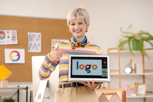 Female graphic designer pointing at laptop in office