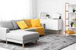© Pixel-Shot - Interior of living room with comfortable sofa, shelving unit and yellow plaid