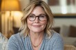 © ChaoticMind - Smiling woman with glasses in cozy living room setting during daytime