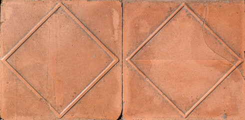 Poster - Close up of two terracotta tiles forming a diamond pattern, ideal for flooring or wall covering, adding a touch of elegance and rustic charm
