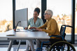 © NDABCREATIVITY - The image includes a person using a wheelchair, depicting inclusivity and teamwork in modern office