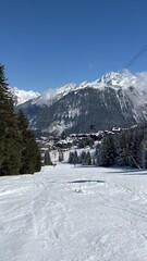 Fototapete - View of Courchevel ski resort slopes and town in the background by winter