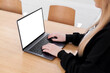 © makanna - Young white woman working on computer with blank copy space screen on table in home office. close up female businesswoman hands typing text, surfing internet on modern laptop. mock up, front view