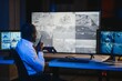 © Serhii - Back view of African American security operator use computer with screens showing surveillance camera footage