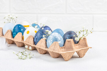 Wall Mural - paper holder with decorated easter eggs on a light background, top view. copy space