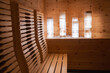 © Aerial Film Studio - Light toned wood paneling and ergonomic seating define this sauna, featuring illuminated cylindrical lights and decorative white stones in Ischgl, Austria.