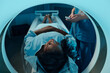 © pressmaster - Medical professional monitoring African American patient during MRI scan session, ensuring accurate positioning and imaging for diagnostic purposes
