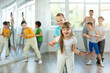 © JackF - Group of children training movements of twist in dance studio with female tutor
