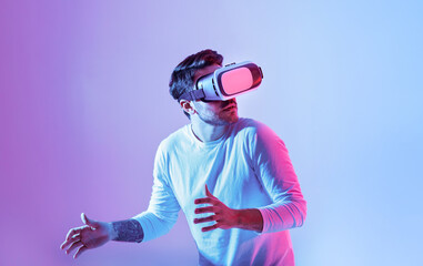 Aufkleber - A man is fully immersed in a virtual reality experience, wearing a VR headset. He displays a surprised expression as he interacts with an unseen digital environment.