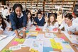 © Rawpixel.com - Diverse group of students collaborating in a library, discussing projects, sharing ideas, and working together around a table filled with colorful papers and notes. Young diverse students learning.