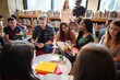 © Rawpixel.com - Diverse group of students studying in a library, reading books and using tablets. Young adults engaged in learning, collaborating in a library setting. Diverse young people reading at library.