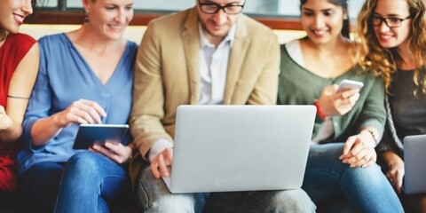 Aufkleber - A diverse group of professionals, including women and men of various ethnicities, collaborate around a laptop. The group engages with technology, sharing ideas and insights together.