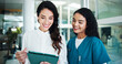 © peopleimages.com - Doctors, smile and women in hospital, tablet and talking with online reading for diagnosis. Employees, coworking and medical with professional, healthcare and tech with results, help or collaboration