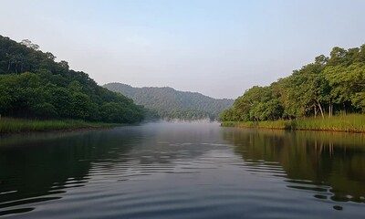 Wall Mural - Tranquil River Scene with Lush Greenery and Clear Reflections on Water in a Misty Morning Environment Surrounded by Mountains