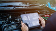 © Thanadon88 - Auto mechanics use tablet computers with cutting-edge interactive diagnostic software to find faulty parts in the engine compartment.