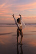 © Cavan - Happy woman at sunset on the ocean, on the beach
