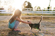© Cavan - Young girl affectionately pets friendly cat in sunny farmyard
