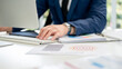 © bongkarn - Closeup of businessman or office worker typing on computer keyboard while putting arm on file folder