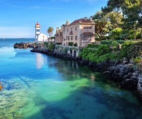 Wall Mural - santa maria lighthouse in cascais, portugal. beautiful calm azure water of the bay.