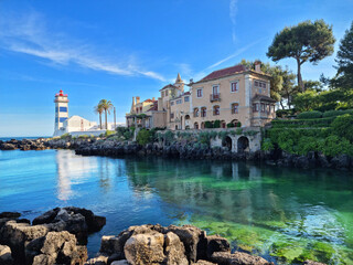 Wall Mural - santa maria lighthouse in cascais, portugal. beautiful calm azure water of the bay.