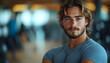 © Mohan - Handsome young man with blond hair and blue eyes, looking directly at the camera, arms crossed, in a casual gray t-shirt