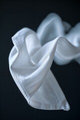 Poster - Elegant white fabric gracefully floating against a dark background in a serene artistic composition