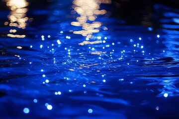 Poster - Rippling blue water illuminated by shimmering lights creates a serene and tranquil atmosphere at night