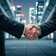 © Goashape-Studio - Firm Business Handshake: A close-up shot of a handshake between two business professionals, sealed the deal. The background features a modern city, lit up at night.